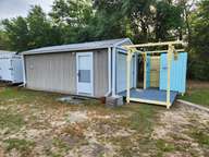 This pic pretty much says it all. The trailer is in the background, hardly worth mentioning there behind the shop (now called Bldg S-1). Bought new in 2013, it served me well. For the last six years it has been a storage shed for yard tools. But no more.